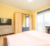 4i mezonet, 133m2, vlastné kúrenie, Melčice-Lieskové - Spálňa v 4-izbovom byte so skriňami, komodou, TV a podlahou s dreveným dekorom.