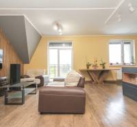 4i mezonet, 133m2, vlastné kúrenie, Melčice-Lieskové - Obývačka 4-izbového bytu s podlahou s dreveným dekorom, pohodlné sedenie a svetlo.