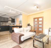 4i mezonet, 133m2, vlastné kúrenie, Melčice-Lieskové - Obývacia izba v 4-izbovom byte s kuchyňou a podlahou s dreveným dekorom.