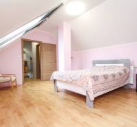 4i mezonet, 133m2, vlastné kúrenie, Melčice-Lieskové - Podkrovná spálňa v 4-izbovom byte s podlahou s dreveným dekorom.