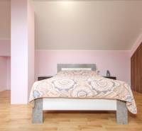 4i mezonet, 133m2, vlastné kúrenie, Melčice-Lieskové - Svetlá spálňa, podlaha s dreveným dekorom, strop so sklonom, pohodlná posteľ, úložný priestor.