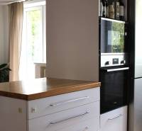 Elegantný 3 izbový byt (78 m²) s 2 balkónmi po kompletnej rekonštrukci - Kuchyňa v 3-izbovom byte, tmavá skrinka so vstavanou rúrou, vedľa chladnička.