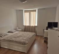 Elegantný 3 izbový byt (78 m²) s 2 balkónmi po kompletnej rekonštrukci - Svetlá spálňa v 3-izbovom byte s posteľou a podlahou s dreveným dekorom.