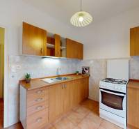 BA/RUŽINOV-Prenájom 1i bytu s balkónom a pivnicou v skvelej lokalite - Kuchyňa v 1-izbovom byte s drevenými skrinkami, bielym sporákom a svetlom na strope.