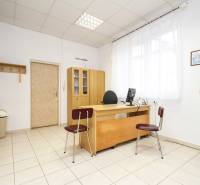 Na predaj ambulancia 101m2, Bratislavská ul. - Žilina - Kancelária s dreveným nábytkom, počítačom a dekoráciami na stenách, dlažba na podlahe.