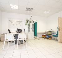 Na predaj ambulancia 101m2, Bratislavská ul. - Žilina - Kancelária s bielym mobiliárom, mapou sveta, zelenou stenou a sanitárnym vybavením a rastlinou.