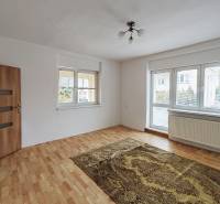 Predaj rodinného domu, Topoľová, Topoľová, Galanta - Izba v rodinnom dome s podlahou s dreveným dekorom, kobercom a veľkým oknom.