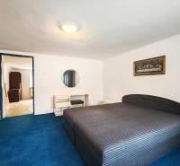 Predaj rodinného domu, Topoľová, Topoľová, Galanta - Spálňa v rodinnom dome s veľkou posteľou, modrý koberec a obraz na stene.