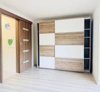 Novostavba 3i bytu s parkovaním, Dvorníky - V 3-izbovom byte sa nachádza vstavaná skriňa a posuvné dvere s dreveným dekorom.