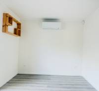 Novostavba 3i bytu s parkovaním, Dvorníky - Minimalistická izba s klimatizáciou a podlahou s dreveným dekorom v 3-izbovom byte.