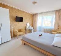 HD reality, predaj 3 izbového bytu na Medvedzí v meste Tvrdošín. - Spálňa v 3-izbovom byte s elegantným nábytkom, zlatou tapetou a bielym kobercom.