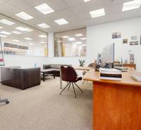 Obchodné, administratívne, priestory, showroom v exponovanej časti TT - Obchodné priestory s dreveným stolom, koženými sedačkami a tabuľou na konferencie.