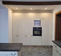 REZERVOVANÉ! Predáme 5-izbový rodinný dom na Štúrovej ulici, Vráble - Kuchyňa s tmavou pracovnou doskou a zabudovanou rúrou, podlaha s dreveným dekorom.