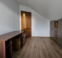 REZERVOVANÉ! Predáme 5-izbový rodinný dom na Štúrovej ulici, Vráble - Izba v rodinnom dome s nábytkom, bielymi stenami a podlahou s dreveným dekorom.