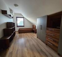 REZERVOVANÉ! Predáme 5-izbový rodinný dom na Štúrovej ulici, Vráble - Podkrovie rodinného domu s nábytkom, podlahou s dreveným dekorom a oknom.
