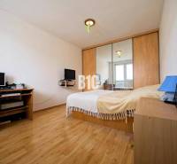 Prerobený 2i byt v príjemnej lokalite Bánoviec nad Bebravou - Spálňa v 2-izbovom byte s podlahou s dreveným dekorom, zrkadlovou skriňou a pracovným stolom.