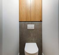 Prenájom úplne nového 2 izb. bytu - skvelá poloha a komfortné bývanie. - Toaleta v 2-izbovom byte s podlahou z tmavého kameňa a drevenými skrinkami.