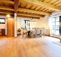 LUKRATÍVNA CHATA - NOVOSTAVBA - SRDCE VRÁTNEJ DOLINY - Otvorený interiér v Chate s podlahou s dreveným dekorom a jedálenským stolom.