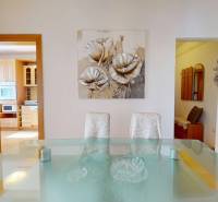 Z vchodu rovno do školy, na predaj praktický 3 izbový byt, Andrusovova - Jedáleň v 3-izbovom byte s preskleným stolom a obrazom kvetov na stene.