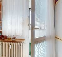 Z vchodu rovno do školy, na predaj praktický 3 izbový byt, Andrusovova - Kuchyňa v 3-izbovom byte s policami, radiátorom a presklenými dverami na balkón.