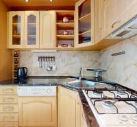 Z vchodu rovno do školy, na predaj praktický 3 izbový byt, Andrusovova - Kuchyňa v 3-izbovom byte s drezom, varnou doskou a drevenými skrinkami.