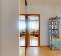 Z vchodu rovno do školy, na predaj praktický 3 izbový byt, Andrusovova - Interiér 3-izbového bytu s podlahou s dreveným dekorom a presklenou vitrínou.