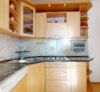 Z vchodu rovno do školy, na predaj praktický 3 izbový byt, Andrusovova - Kuchyňa s drevenými skrinkami a pultom, podlaha s dreveným dekorom v 3-izbovom byte.