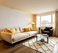 REZERVOVANÉ- Na predaj 3-izbový byt Žilina-Vlčince - Svetlá obývačka s pohovkou v 3-izbovom byte, podlaha s dreveným dekorom, veľké okno.