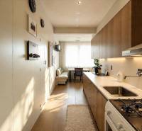 REZERVOVANÉ- Na predaj 3-izbový byt Žilina-Vlčince - Útulná kuchyňa v 3-izbovom byte s podlahou s dreveným dekorom a moderným zariadením.