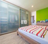 Príjemný 4 izbový byt s balkónom - Klokočina - Spálňa v 4-izbovom byte s podlahou s dreveným dekorom a priestrannou skriňou.