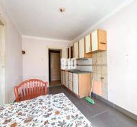 Rodinný dom s veľkým pozemkom (4641 m2)  - Ondrejovce - Kuchyňa s jednoduchými skrinkami, kachličkami a stolom v rodinnom dome.