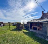 Rodinný dom s veľkým pozemkom (4641 m2)  - Ondrejovce - Rodinný dom v Ondrejovciach so záhradou, prístreškom a výhľadom na prírodu v slnečnom počasí.