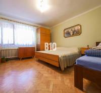 Rodinný dom s krásnym veľkým pozemkom ( stavebným) - Nové Sady - Spálňa s drevenou podlahou a jednoduchým nábytkom v rodinnom dome.