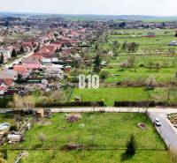 Jelenec  - Nádherný pozemok pri lese - 687 m2 - Letecký pohľad na obec Jelenec s rozsiahlou oblasťou vhodnou pre pozemky - bývanie.