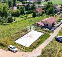 Základová doska na  575 m2 pozemku - Čeľadice - Pozemky - bývanie v Čeľadiciach zobrazujú základovú dosku medzi domami a zeleňou.