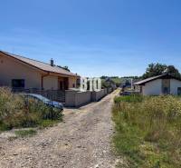 Základová doska na  575 m2 pozemku - Čeľadice - Rodinné domy pri ceste obklopenej trávou v Čeľadiciach, Pozemky - bývanie.