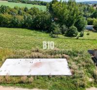 Základová doska na  575 m2 pozemku - Čeľadice - Pozemok na bývanie v Čeľadiciach, zelená krajina s betónovým základom a automobilom.