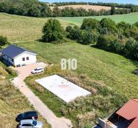 Základová doska na  575 m2 pozemku - Čeľadice - Záber na pozemok pre bývanie v Čeľadiciach zahŕňa dom, zeleň a autá.