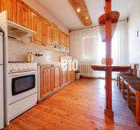 Rodinný dom s nádherným 8 árovým pozemkom na Kamennej ulici - Kuchyňa v rodinnom dome s dreveným dekorom a jedálenským kútom.