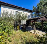 Rodinný dom s nádherným 8 árovým pozemkom na Kamennej ulici - Rodinný dom na Kamennej ulici v Nitre obklopený zeleňou a prístreškom pre auto.