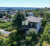 Rodinný dom s nádherným 8 árovým pozemkom na Kamennej ulici - Pohľad na rodinný dom na ulici Kamenná v Nitre obklopený zeleňou a mestskou panorámou.