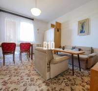 Rodinný dom s nádherným 8 árovým pozemkom na Kamennej ulici - Obývacia izba v rodinnom dome s kobercom a červenými stoličkami.