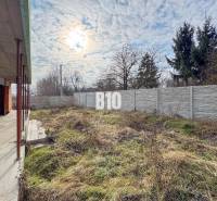 6 izbový rodinný dom  - DVOJGARÁŽ - CABAJ časť Riegler - Stavba rodinného domu s trávnatým pozemkom a oplotením, pod zamračenou oblohou.