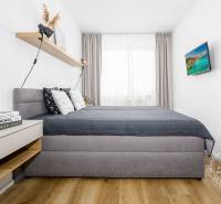 TOP lokalita na začiatku Petržalky, DVE VEŽE, Bosákova ul. - Spálňa v 2-izbovom byte s pohodlnou posteľou, poličkou a podlahou s dreveným dekorom.