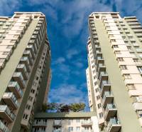 TOP lokalita na začiatku Petržalky, DVE VEŽE, Bosákova ul. - Bytové domy s balkónmi na Bosákovej ulici v Bratislave, Petržalke pod modrou oblohou.