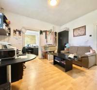 Na predaj rodinný dom s podnikateľským potenciálom, TN-Záblatie - Izba v rodinnom dome so sedačkou, stolom a kancelárskym vybavením na drevenej podlahe.