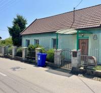 Na predaj rodinný dom s podnikateľským potenciálom, TN-Záblatie - Rodinný dom na Záblatskej ulici v Trenčíne so záhradou a modrou nádobou na odpad.