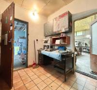 Na predaj objekt vhodný na podnikanie – Trenčín, Záblatie - Interiér obchodných priestorov s dlažbou, pracovným stolom a náradím na poličkách.