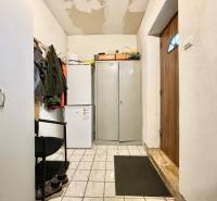 Na predaj objekt vhodný na podnikanie – Trenčín, Záblatie - Interiér rodinného domu s chladničkou, skriňou a bundami na vešiaku.