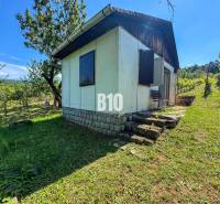 Vinica na skok od Nitry + chata - 590 m2 - Drevená chatka uprostred viníc v Nitre, obklopená zeleňou a stromami.